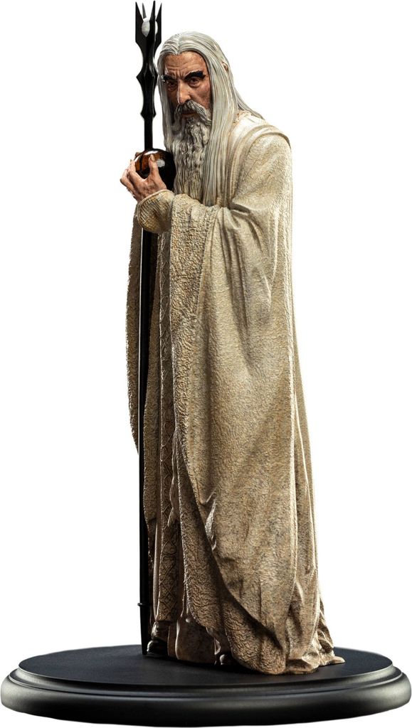 A statue of the character Saruman the White from The Lord of the Rings, standing on a black base.