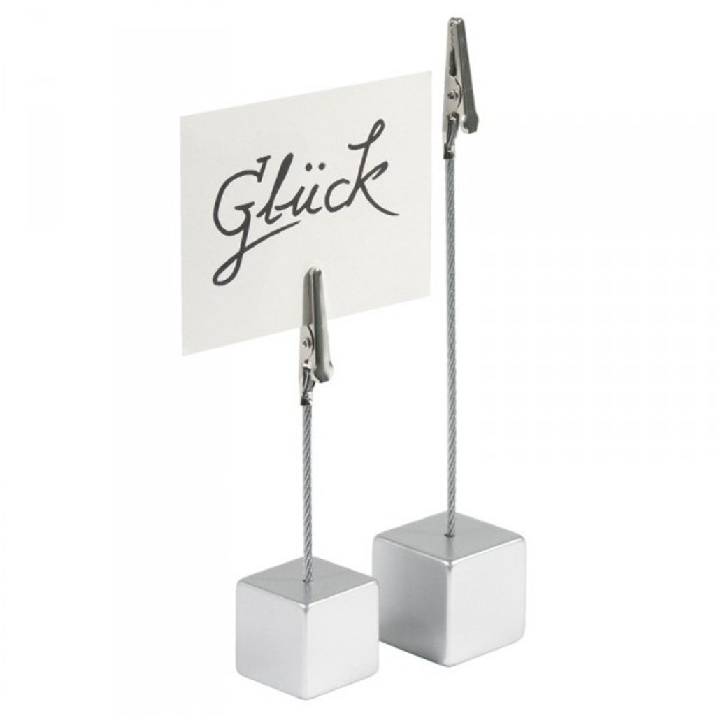 Two silver cube-shaped card holders with clips, one holding a white card with the word "Glück" written in black script.
