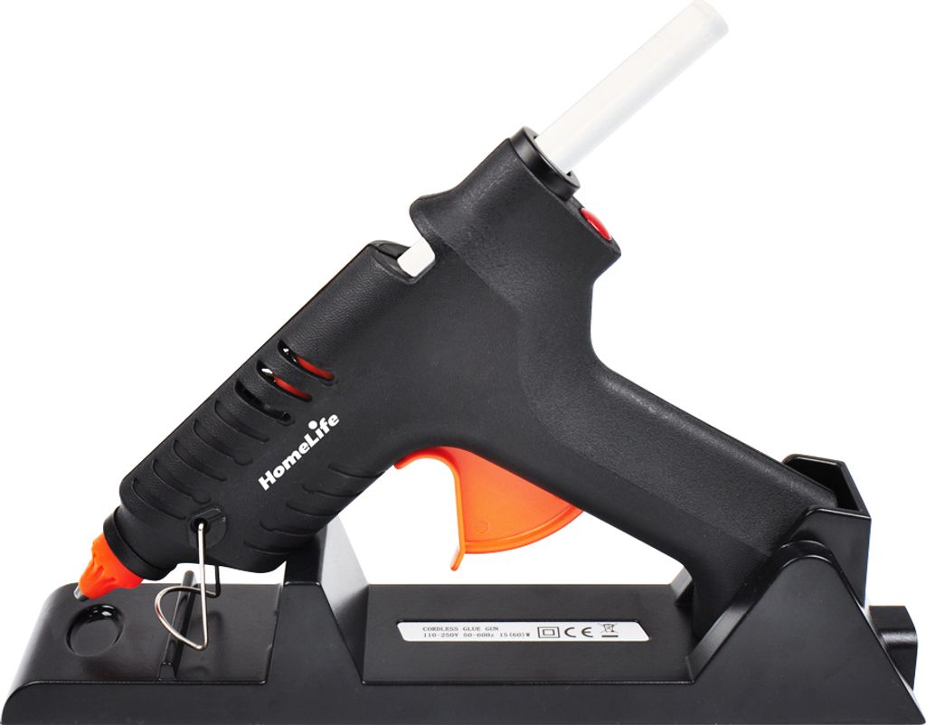 A black and orange cordless hot glue gun is shown resting on its black charging stand against a white background.