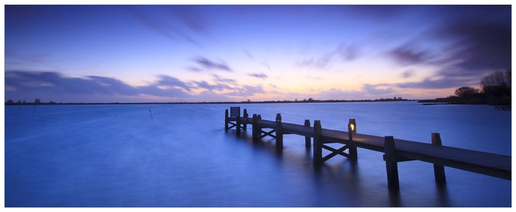 Wallario Wandbild aus Acryl, 200 x 80 cm, freischwebende Optik - Steg bei Abenddämmerung - Blauer Himmel bei Nacht
