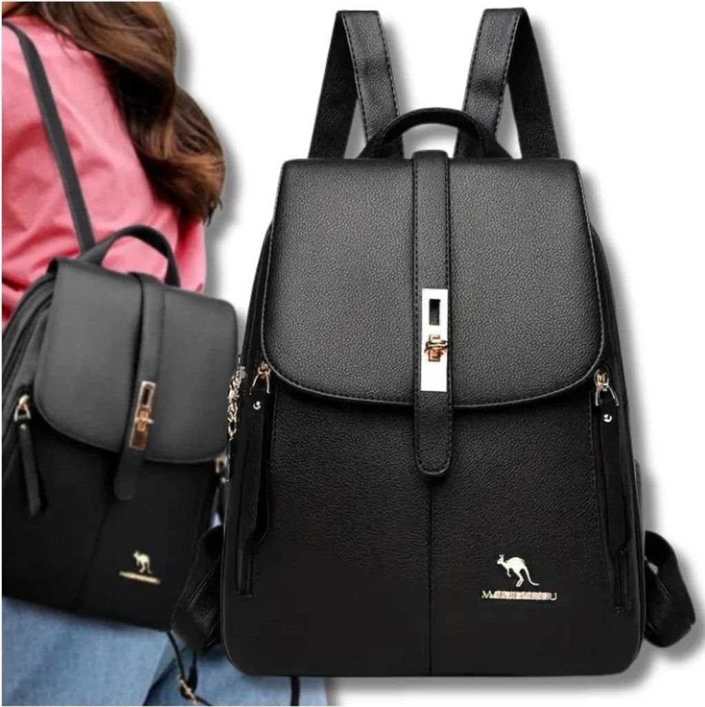 Two black leather backpacks are shown, one in the foreground and one slightly behind and to the left. A person's shoulder and arm are visible on the left side of the image, wearing a pink top.