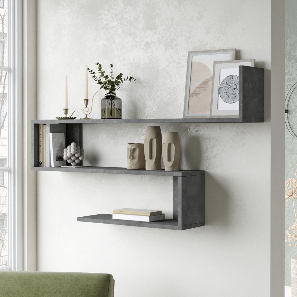 A modern living room with a grey concrete-effect wall-mounted shelf unit displaying decorative items and books.