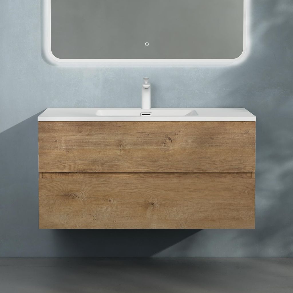 A wall-mounted bathroom vanity with a sink and faucet, set against a textured blue wall.