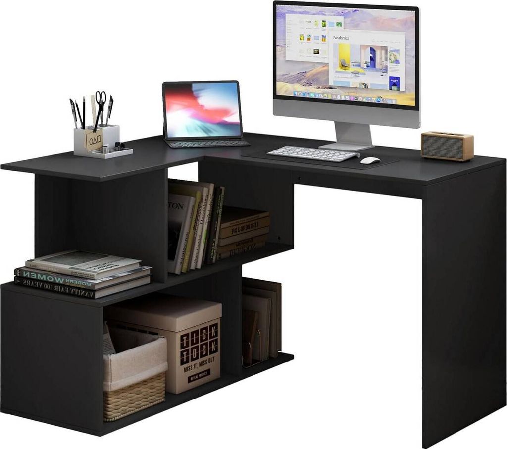 A black L-shaped desk with shelves, a laptop, a desktop monitor, keyboard, mouse, and a speaker.
