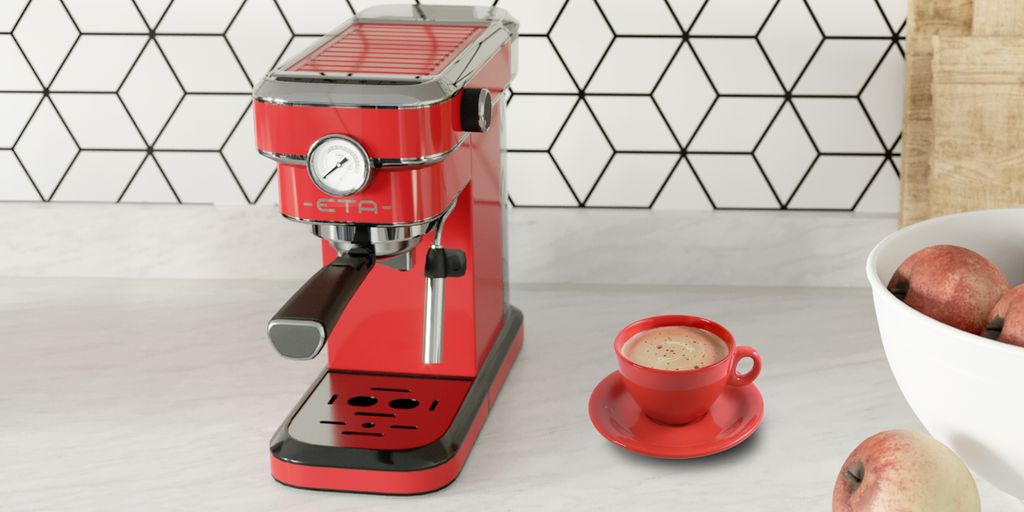 A red espresso machine is shown on a countertop with a cup of coffee and a bowl of apples.