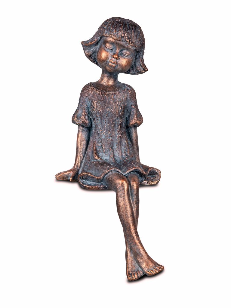 A bronze-colored figurine of a young girl sitting with her eyes closed.