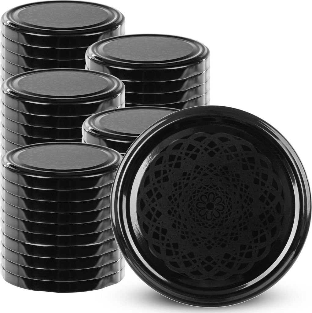 A stack of black jar lids and one lid in the foreground with a decorative pattern.