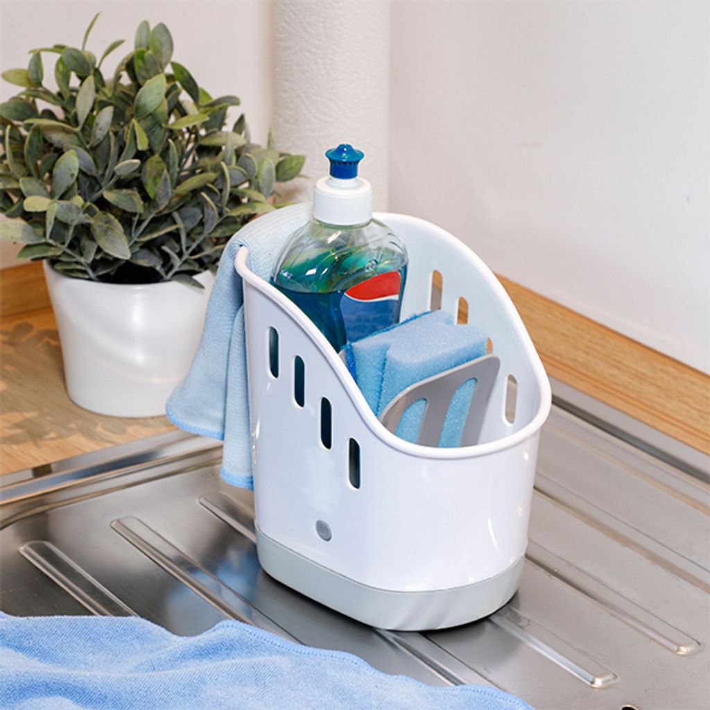 A kitchen sink area with a dish soap organizer, sponges, and a dish towel.
