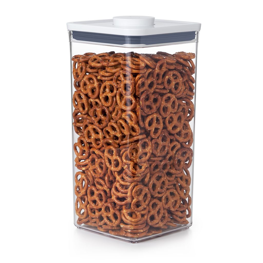 A clear, well-lit studio shot of a clear plastic food storage container filled with pretzels.