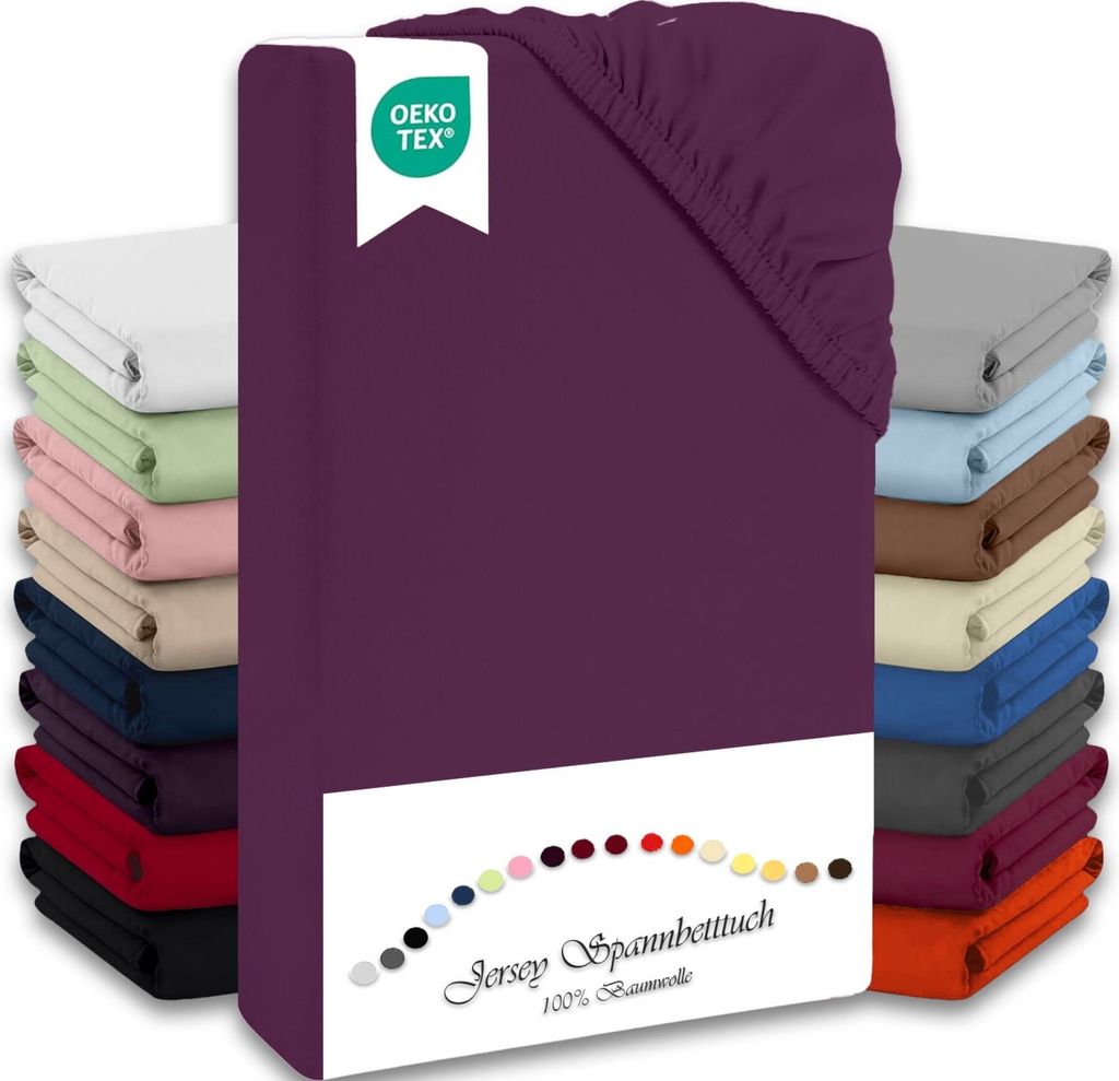 A stack of folded jersey fitted sheets in various colors, with a prominent aubergine colored sheet in the foreground, featuring an OEKO-TEX logo and a color swatch with text.