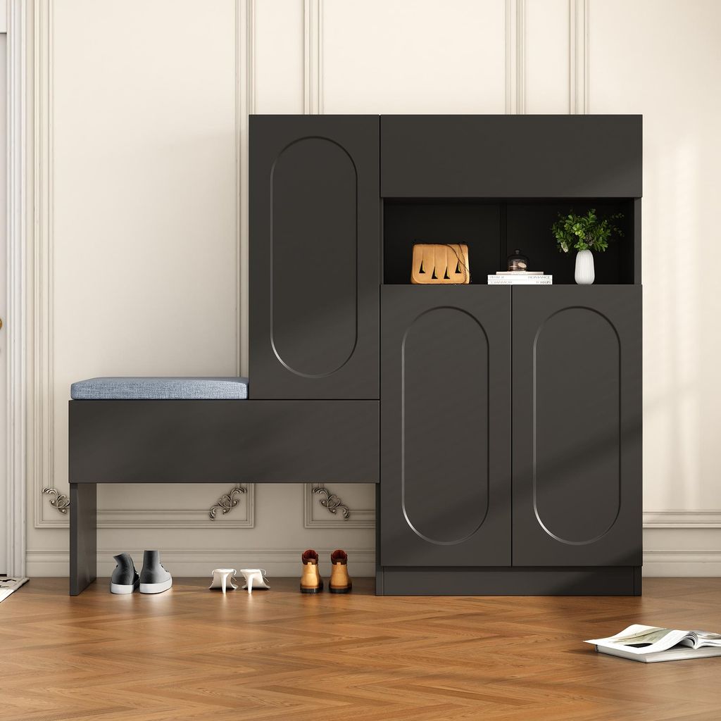 A dark gray shoe cabinet with an integrated bench and blue cushion, placed in a room with wooden flooring and white paneled walls.