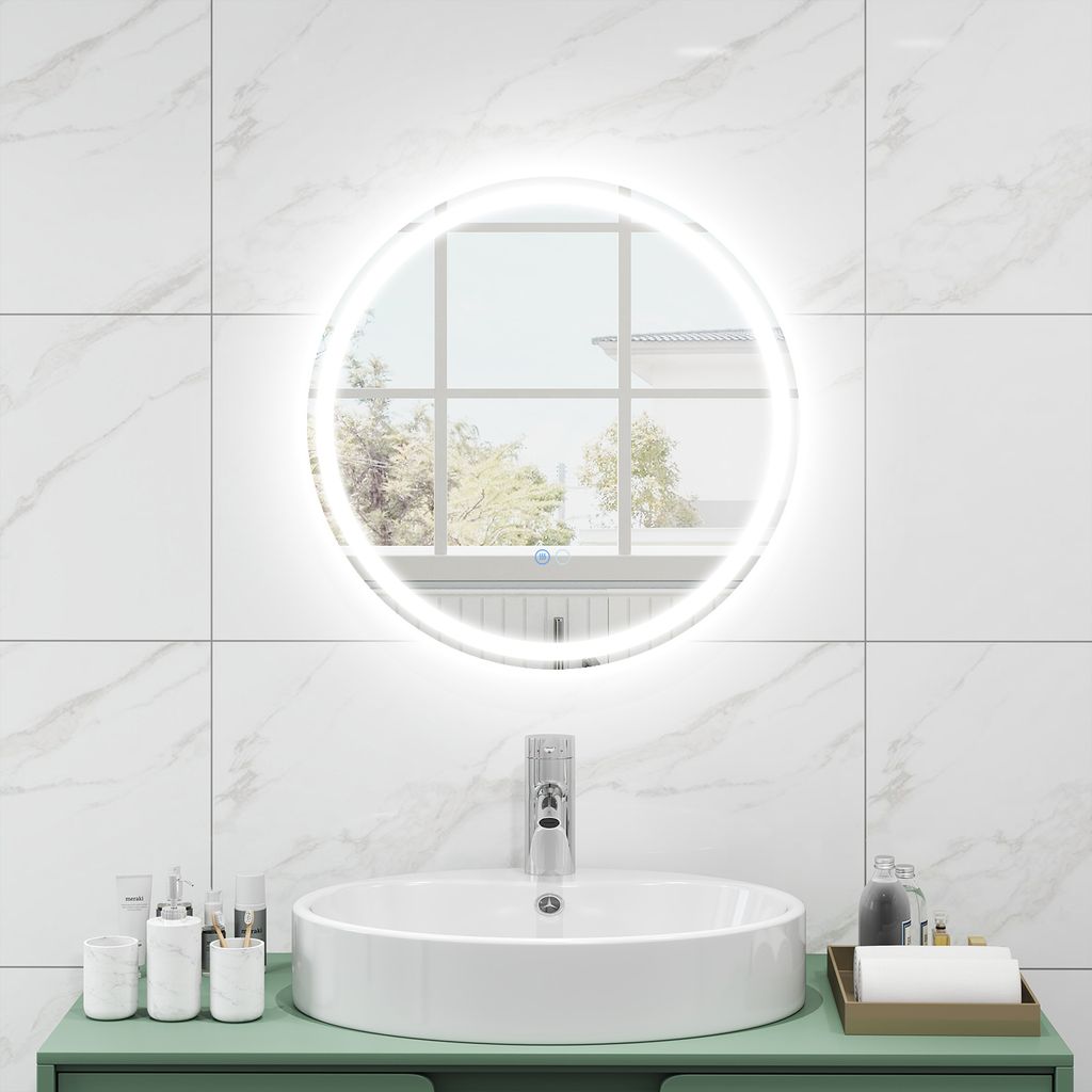 A round LED bathroom mirror is mounted above a sink.