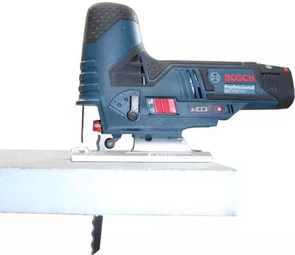 A Bosch jigsaw cutting into a piece of white material.