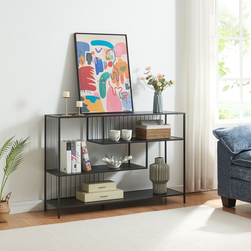 A console table with decorative items and books on it, placed in a living room setting.