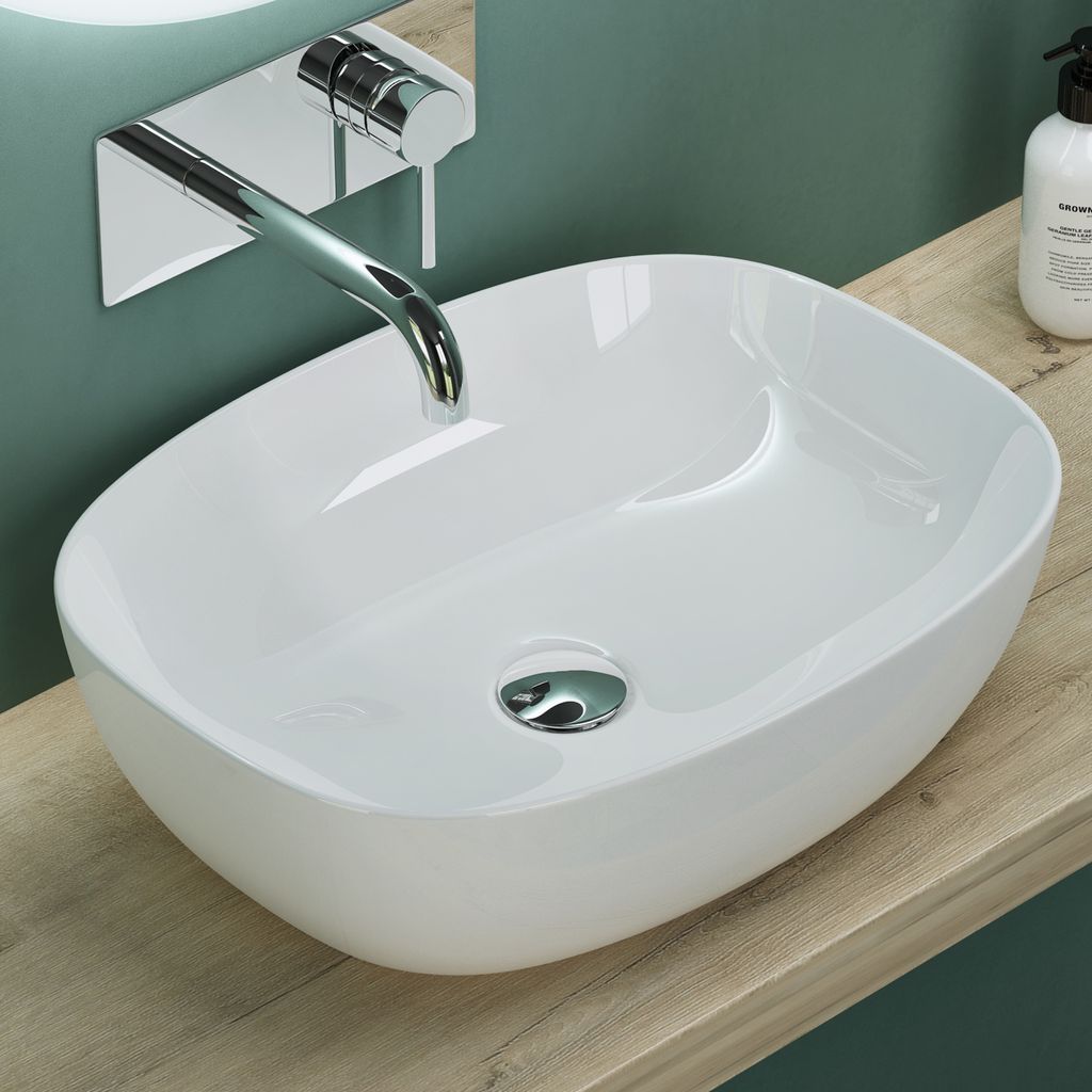 A white ceramic sink with a chrome faucet is shown on a wooden countertop against a teal wall.
