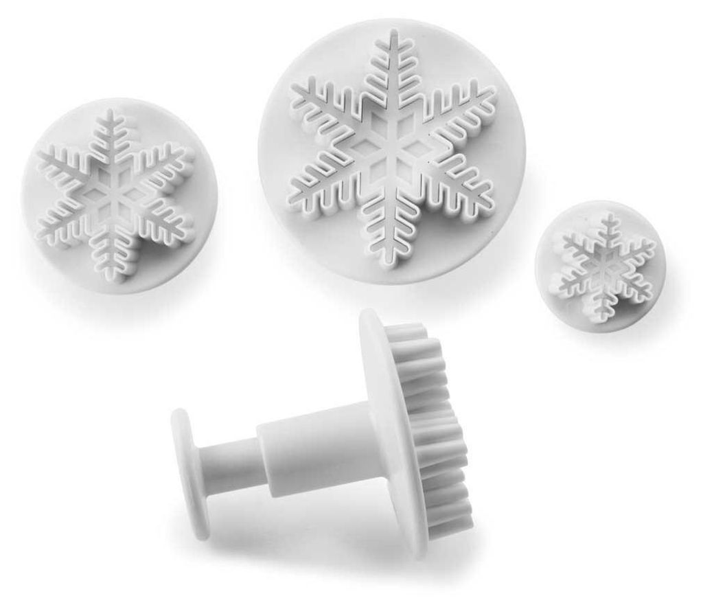 A set of three white snowflake-shaped cookie cutters on a white background.