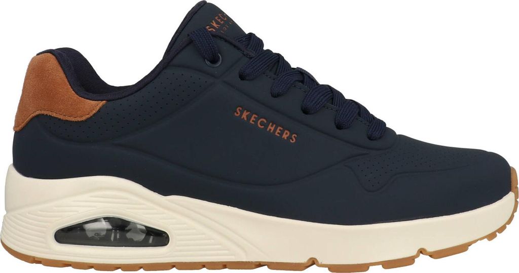 A side view of a navy blue Skechers sneaker with a tan heel accent and a cream-colored sole.