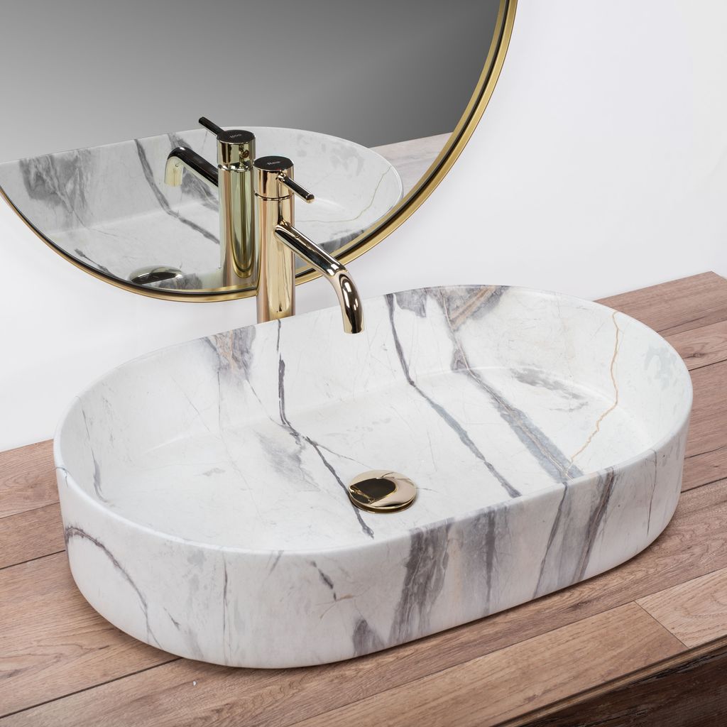 A marble-effect basin with a gold faucet is shown on a wooden surface, with a mirror reflecting the scene.