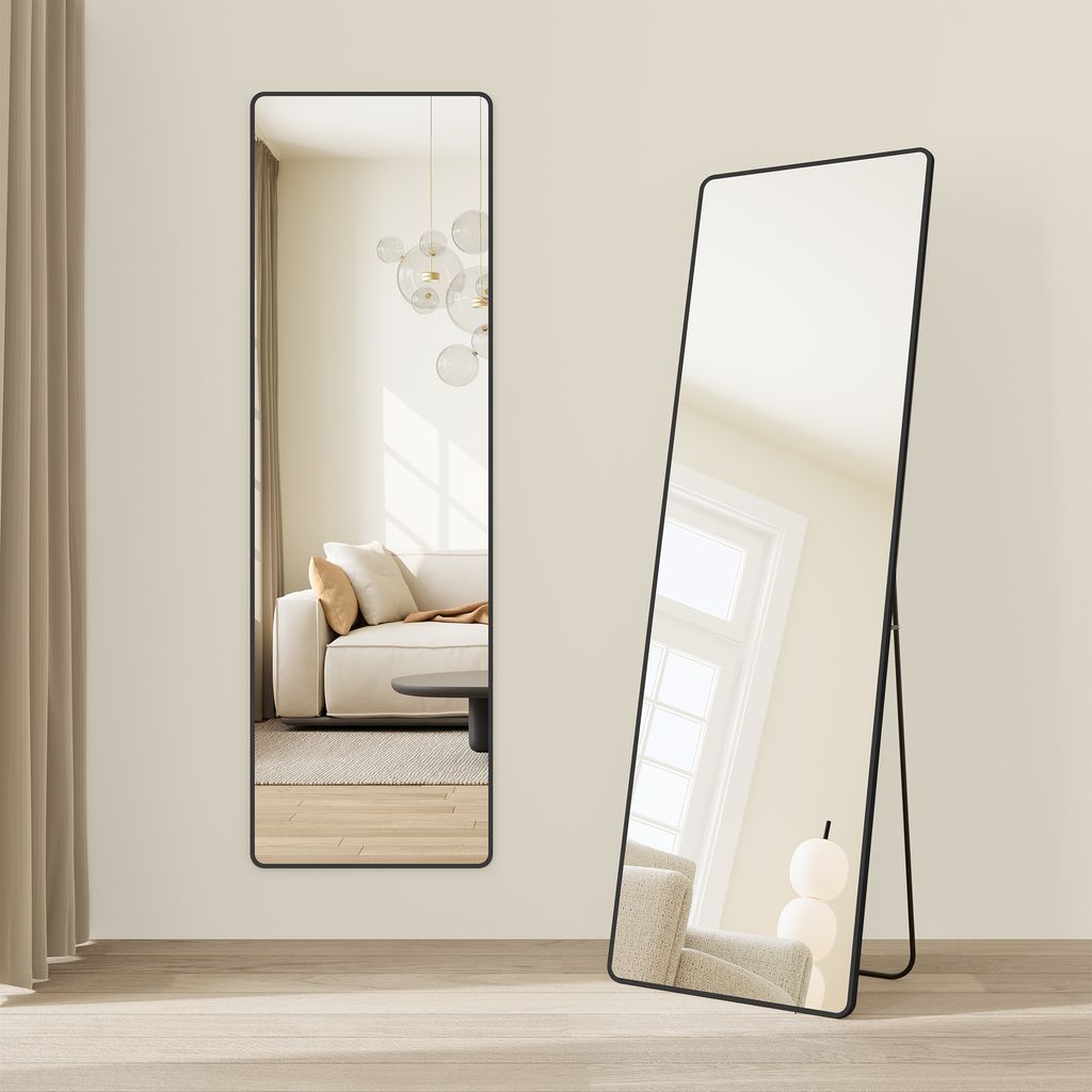 Two full-length mirrors are displayed in a room setting with a sofa and a window visible in the reflections.