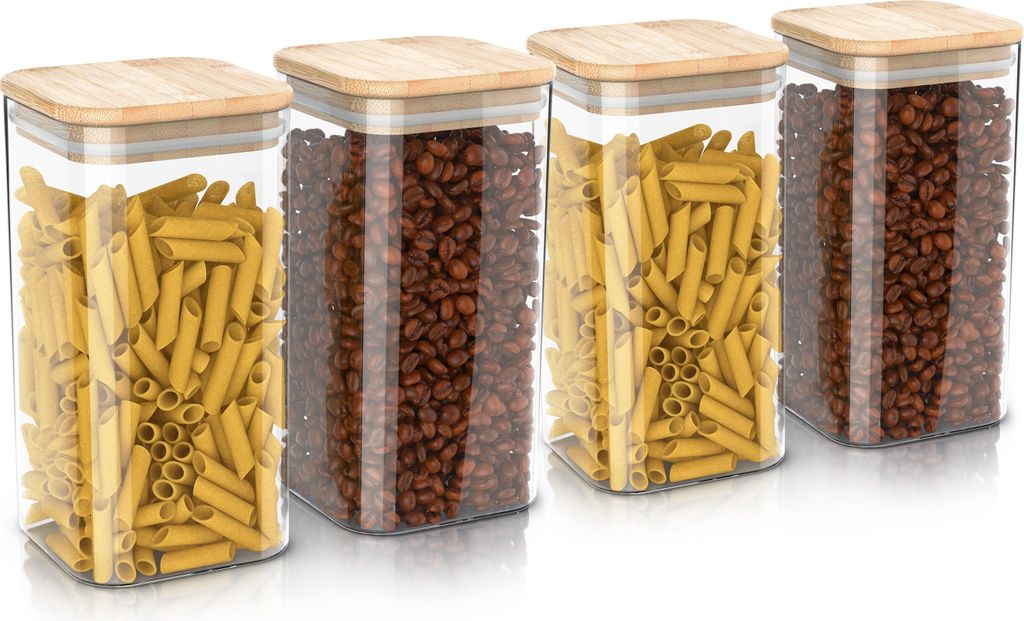Four glass storage jars with bamboo lids, filled with pasta and coffee beans, are arranged in a row on a white background.