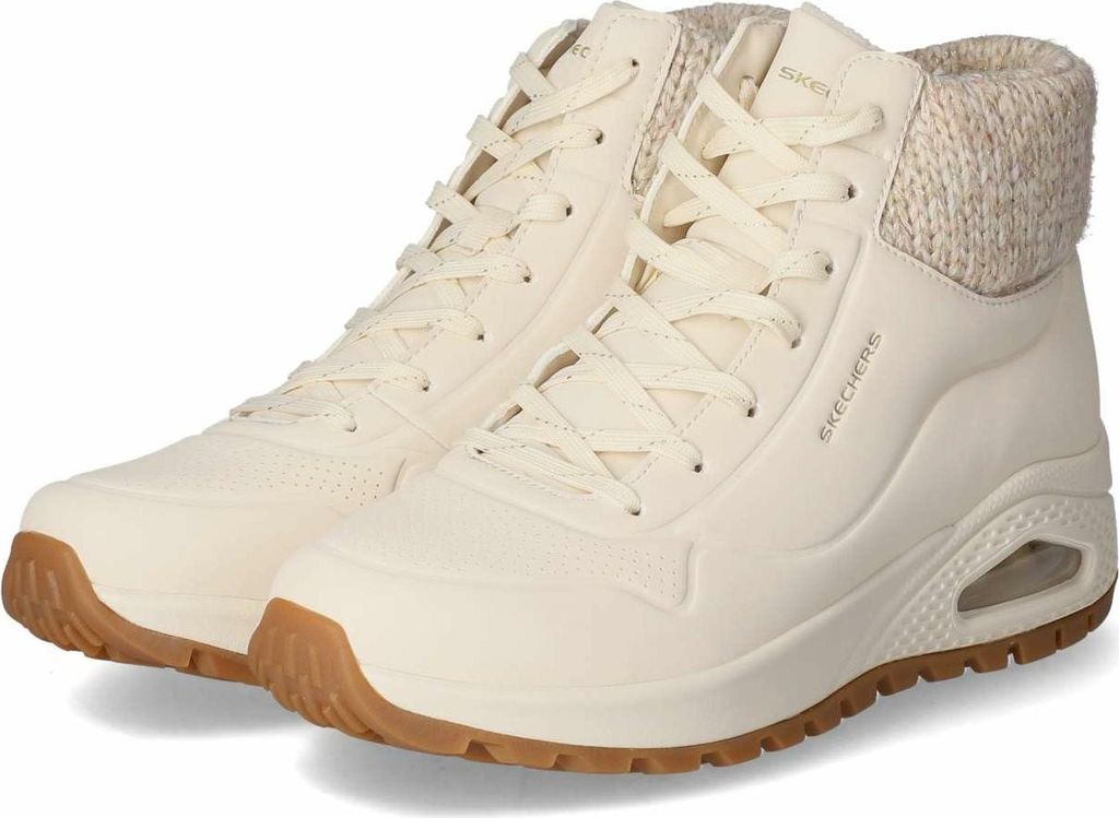A pair of cream-colored Skechers boots with tan soles and knitted cuffs, presented against a white background.