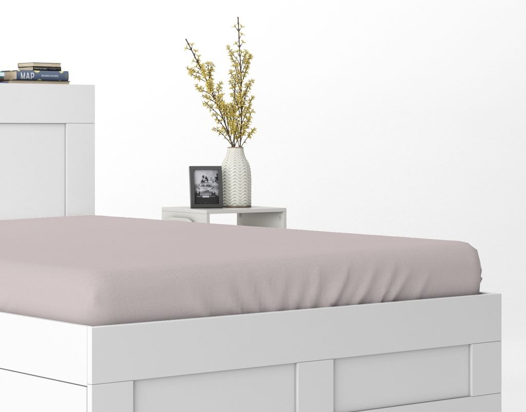A close-up view of a white bed frame with a pink fitted sheet.