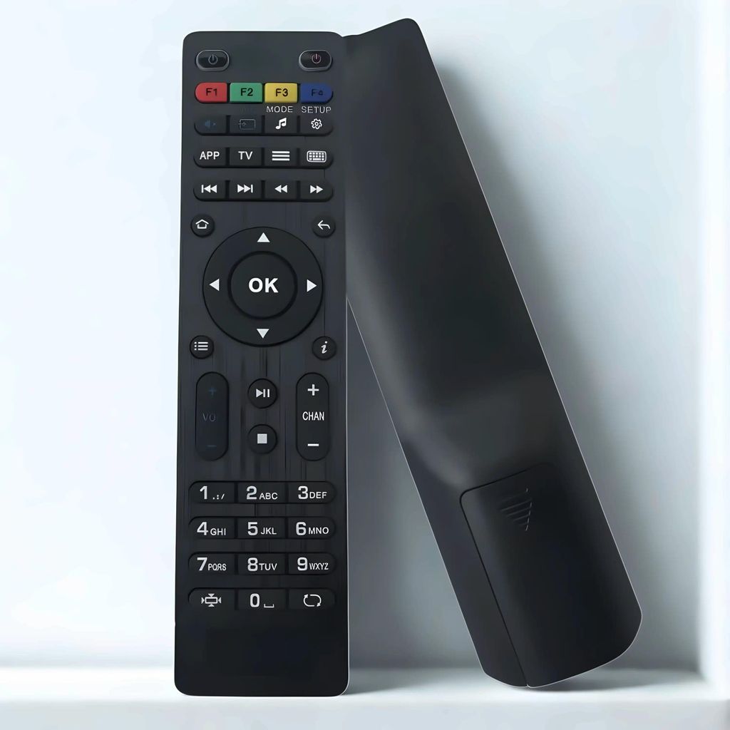 A black remote control is leaning against a white surface.