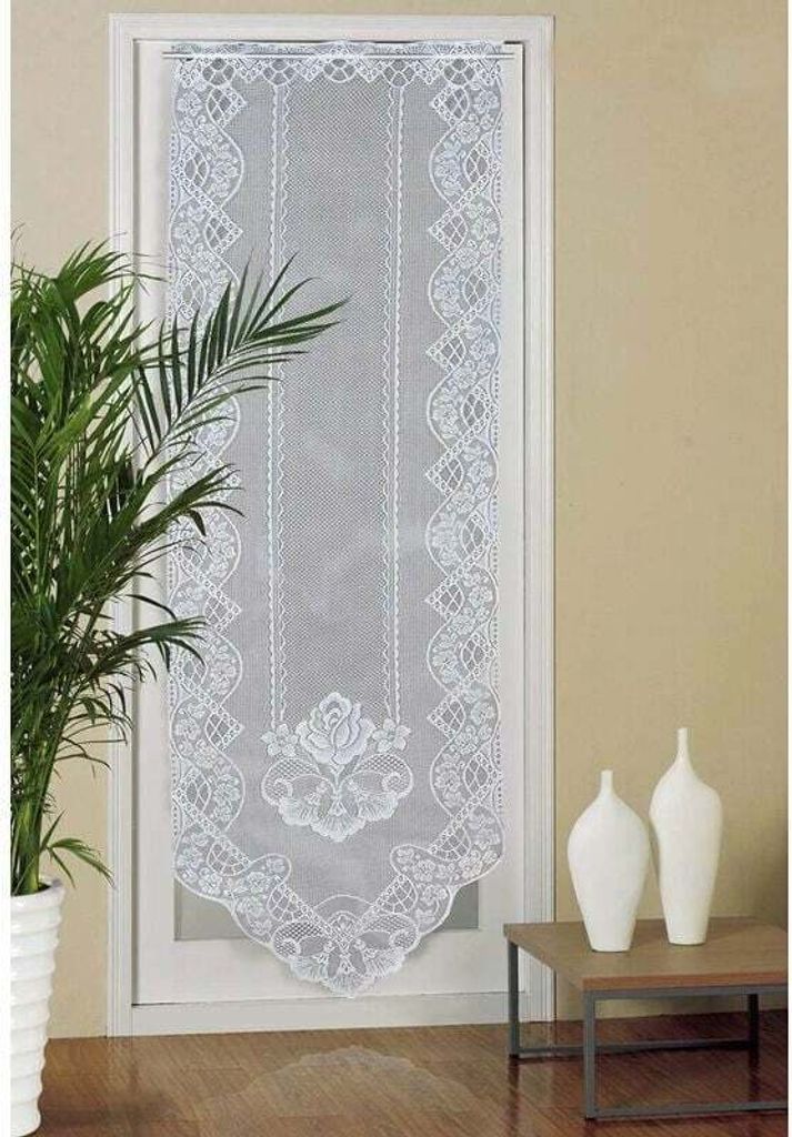 A white lace door curtain hanging on a door frame, with a potted plant to the left and decorative vases on a table to the right.