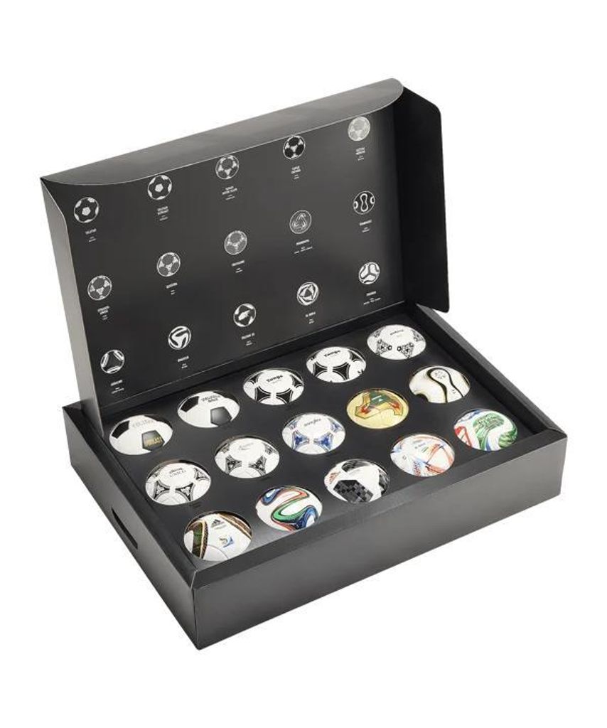 A black box containing a set of mini soccer balls, with images of historical soccer balls printed on the inside lid.