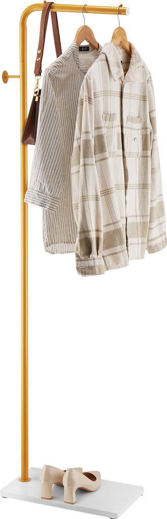 A clothing rack with two shirts and a handbag hanging on it, and a pair of shoes on the base.