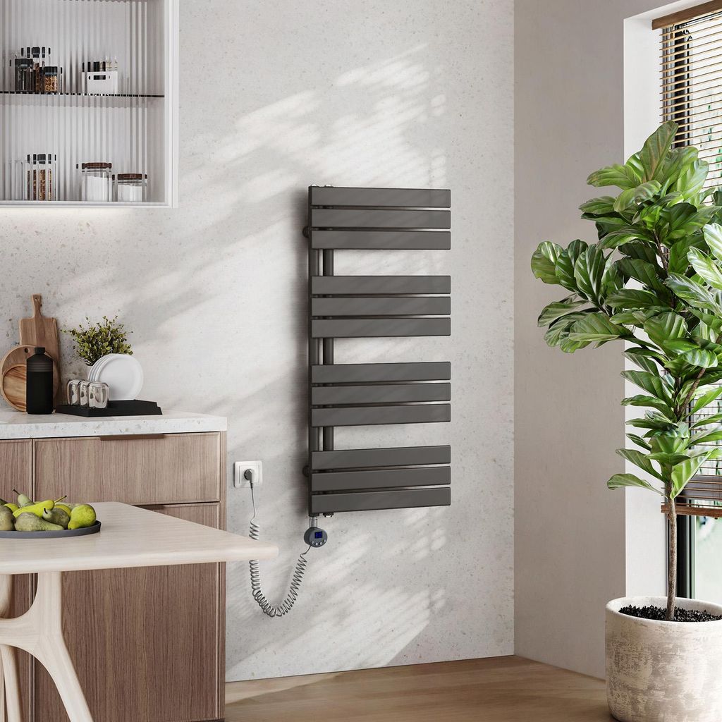 A modern kitchen or bathroom setting with a towel warmer, cabinets, and a plant.