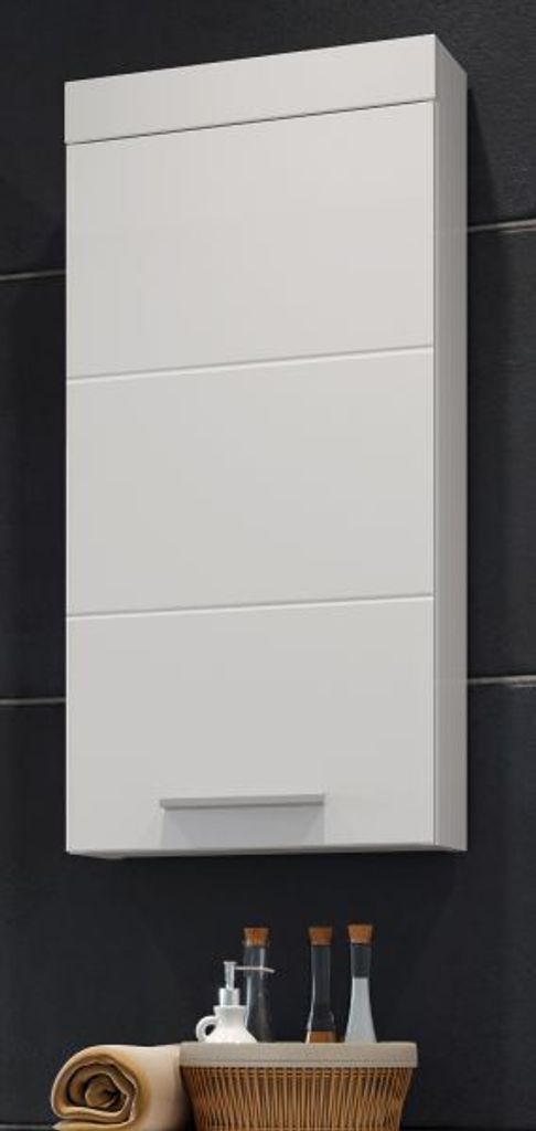 A white wall-mounted cabinet with a silver handle is shown against a dark tiled wall.