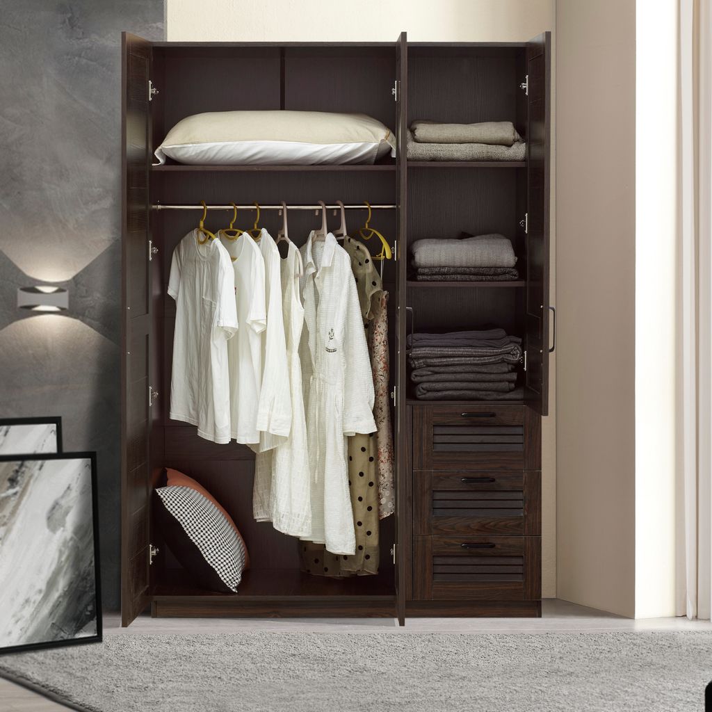 An open wardrobe with clothes hanging and folded on shelves and in drawers. A pillow and decorative pillows are also visible.