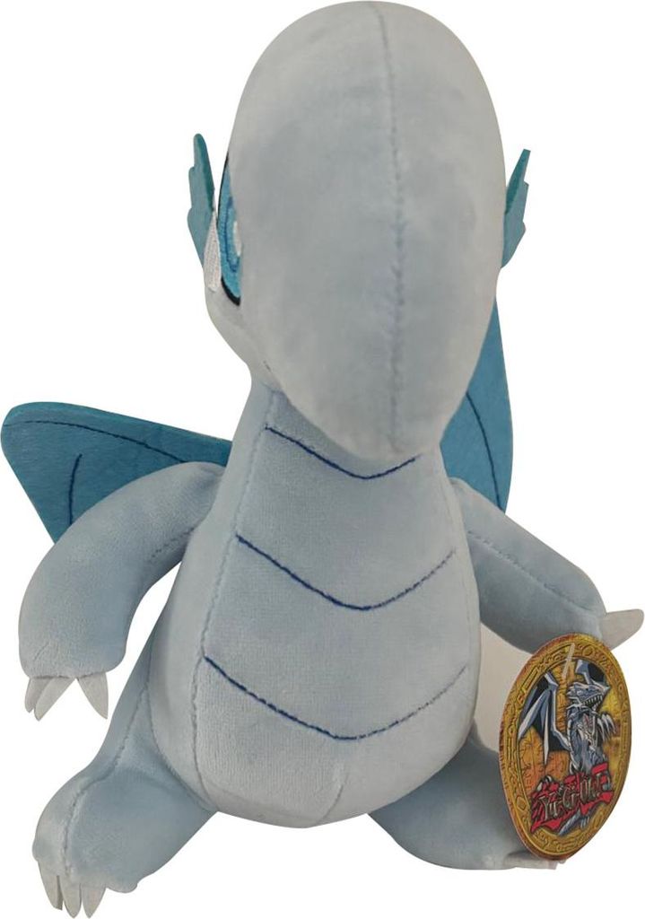 A plush toy of a blue-eyed white dragon from Yu-Gi-Oh! is shown from the back, sitting down.