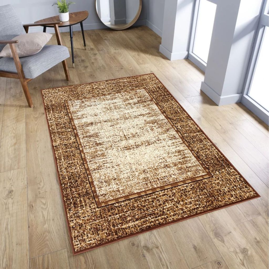 A rug is placed on a wooden floor in a room with a chair and a table.