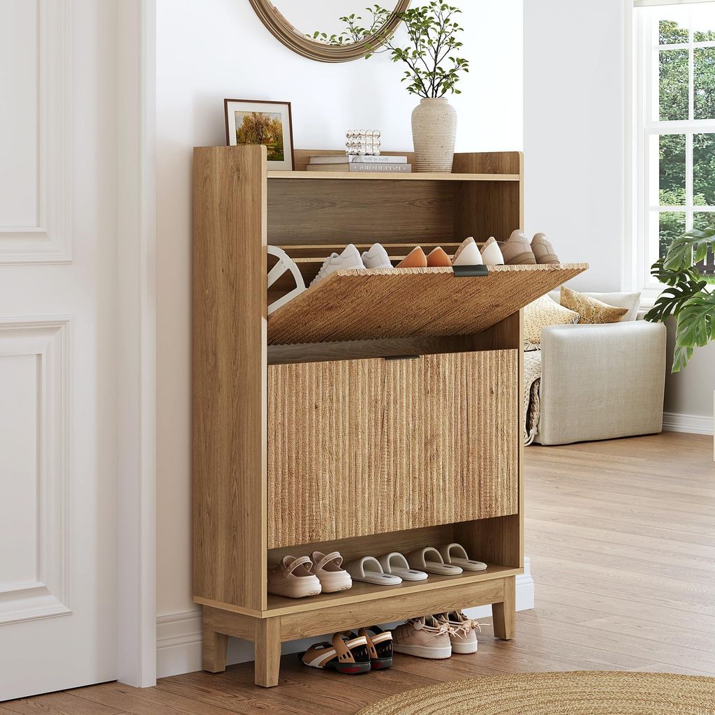 A wooden shoe cabinet with open drawers and shoes inside, placed in a hallway next to a door and a window.