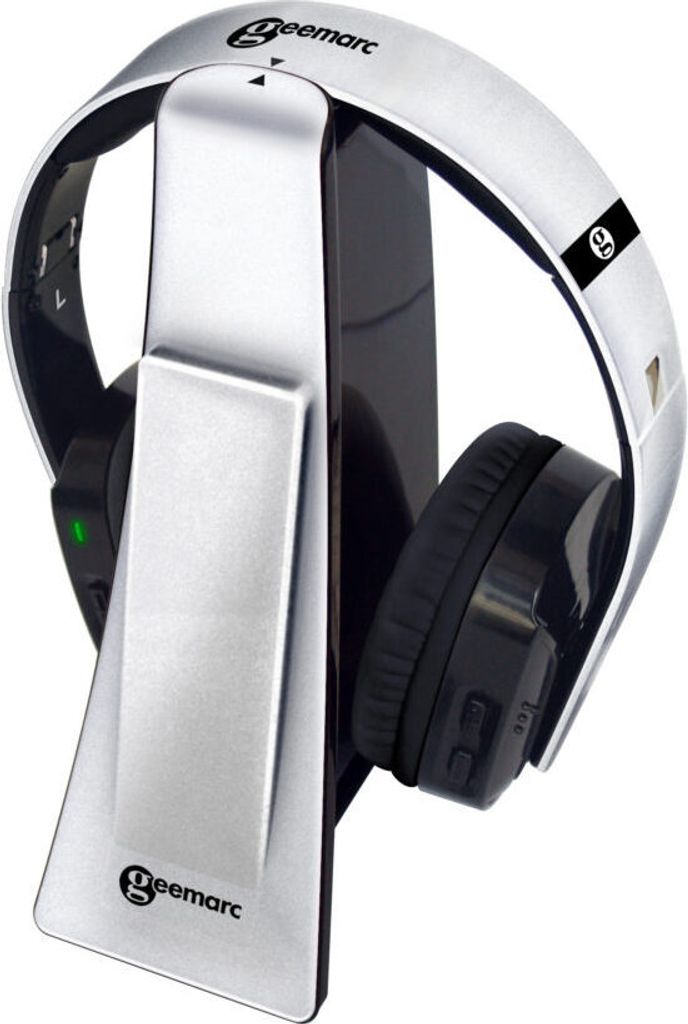 A pair of silver and black wireless headphones resting on their charging stand.