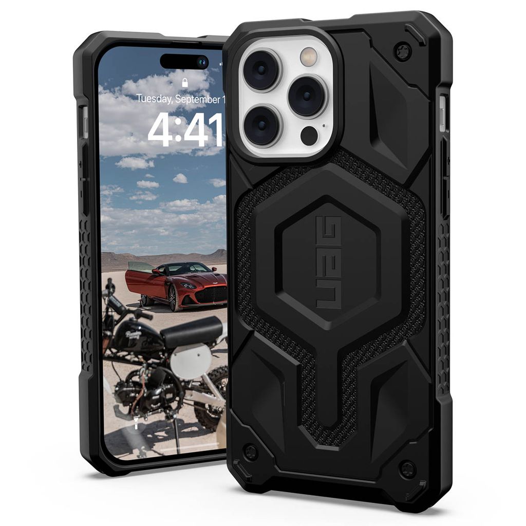A black UAG Monarch protective case for an iPhone 14 Pro Max is shown, with the phone's screen displaying a motorcycle and a red car in a desert landscape.