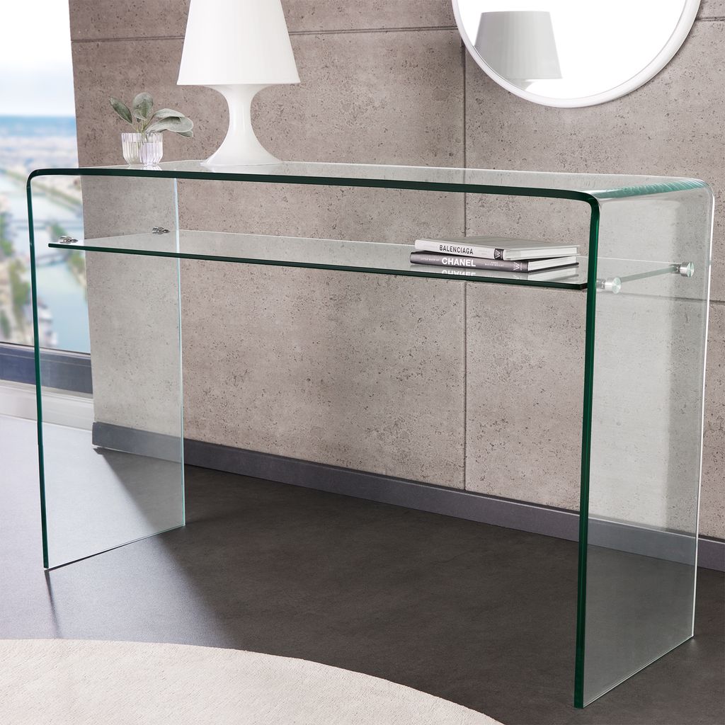 A modern glass console table with a shelf, placed near a window with a view of a city.