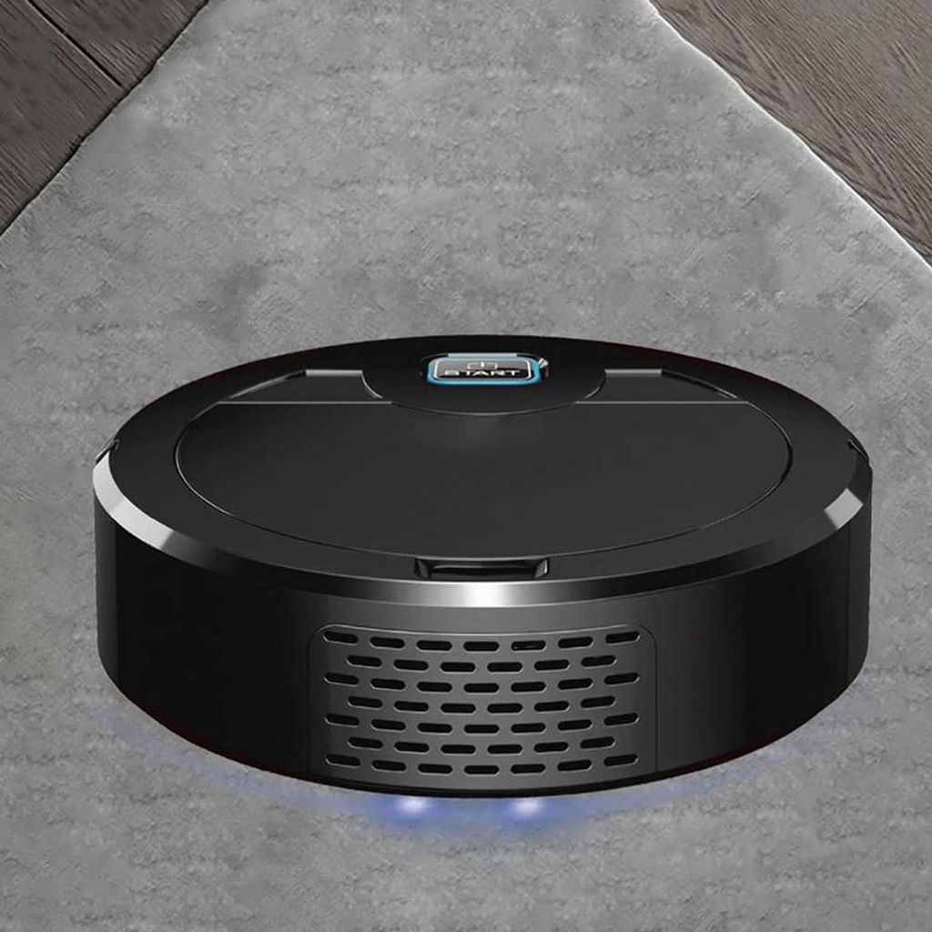A black robotic vacuum cleaner is shown on a gray carpet with a hint of wooden flooring in the background.