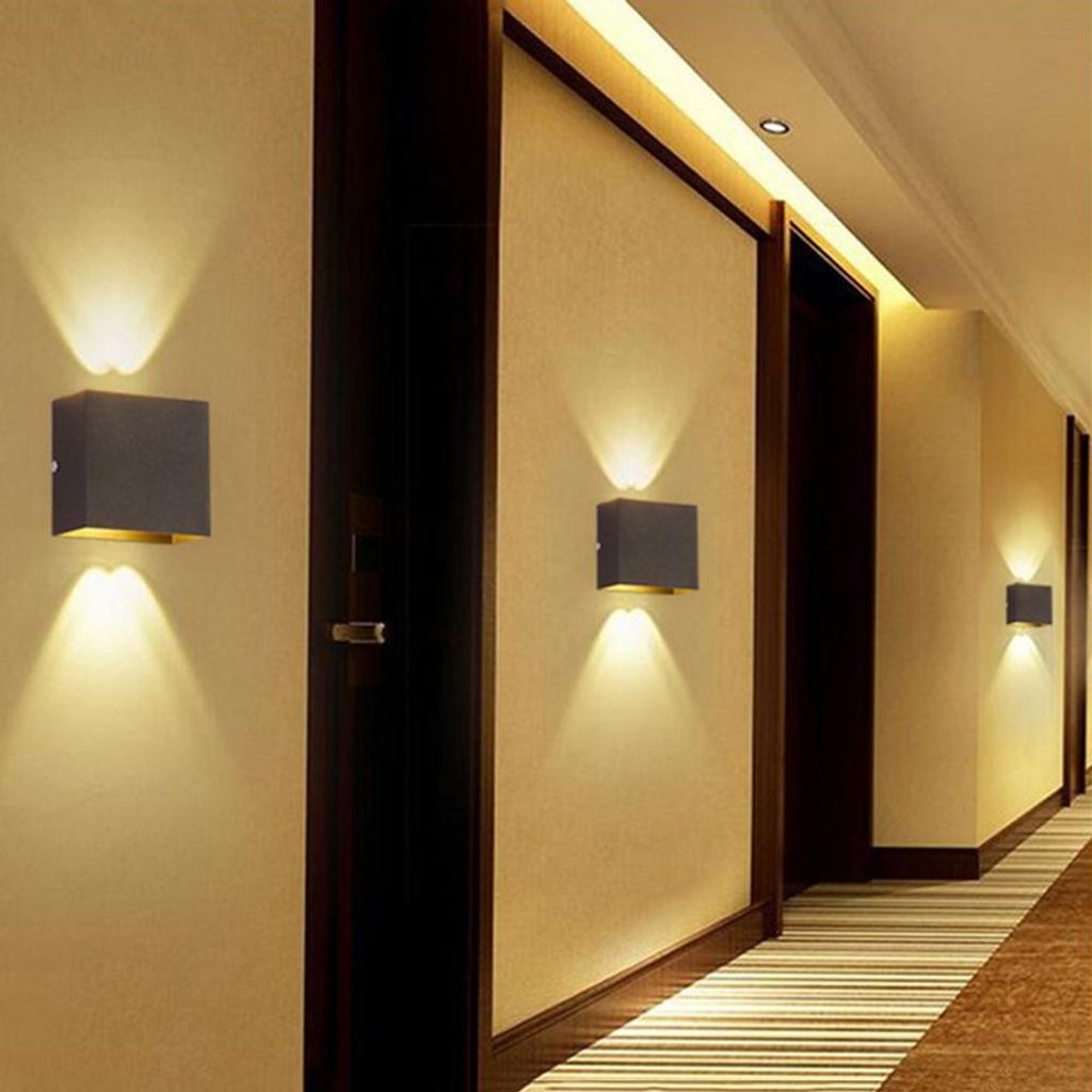 A hallway with modern wall lights illuminating the space.