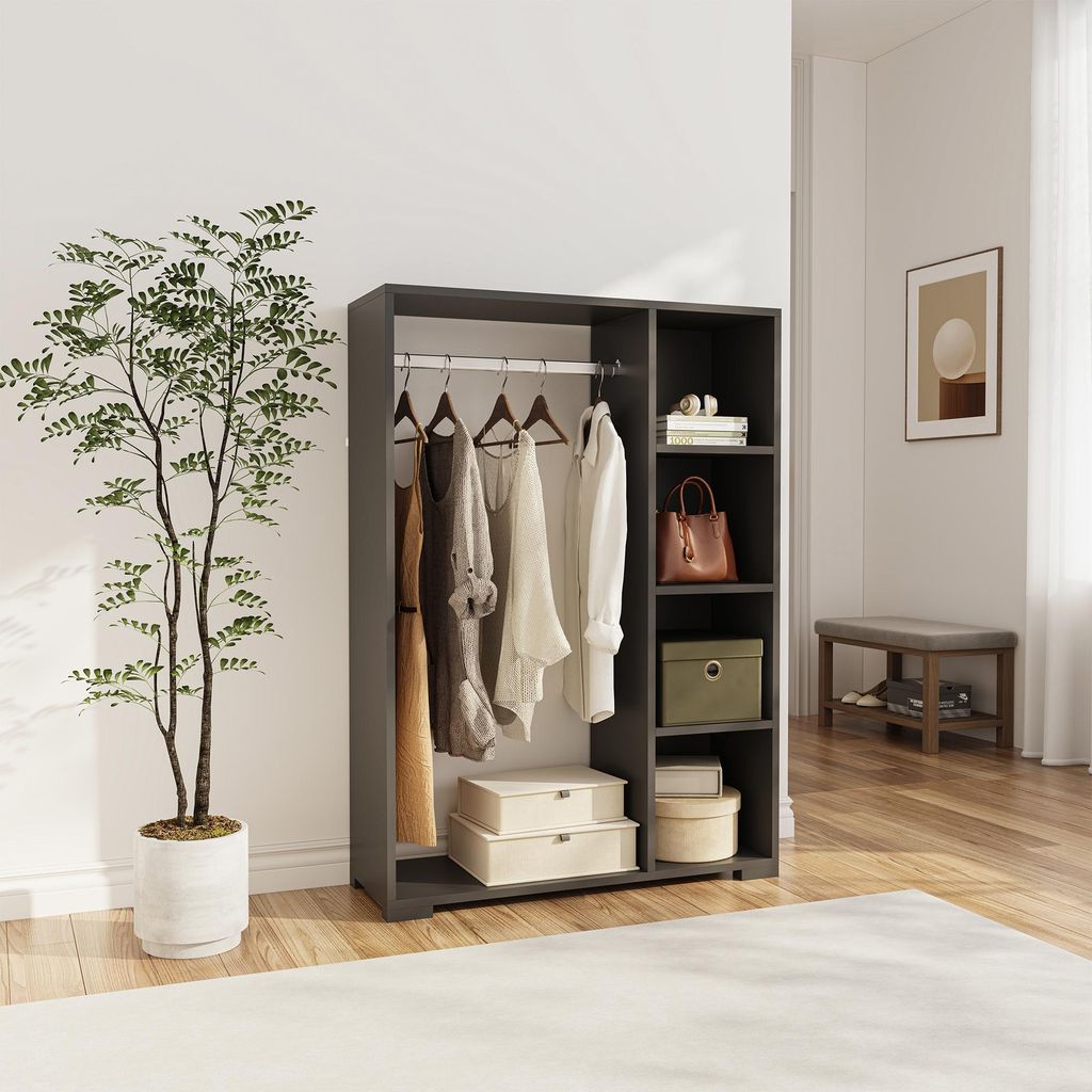 A wardrobe with clothes hanging on a rail and shelves with storage boxes and a handbag.