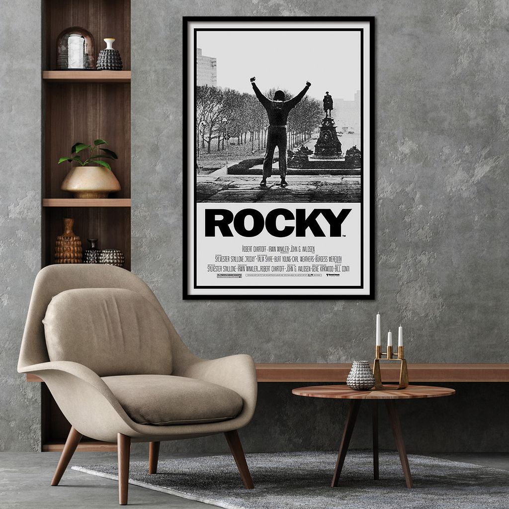 A movie poster for Rocky is displayed on a wall above a chair and a coffee table.