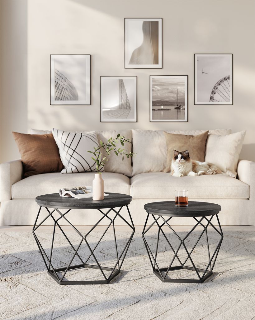 A living room scene with a sofa, coffee tables, and wall art.