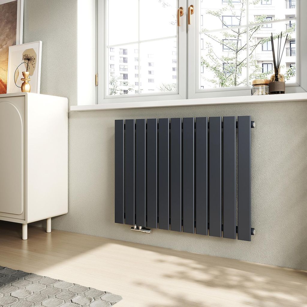 A modern living room with a white cabinet and a dark gray radiator under a window.