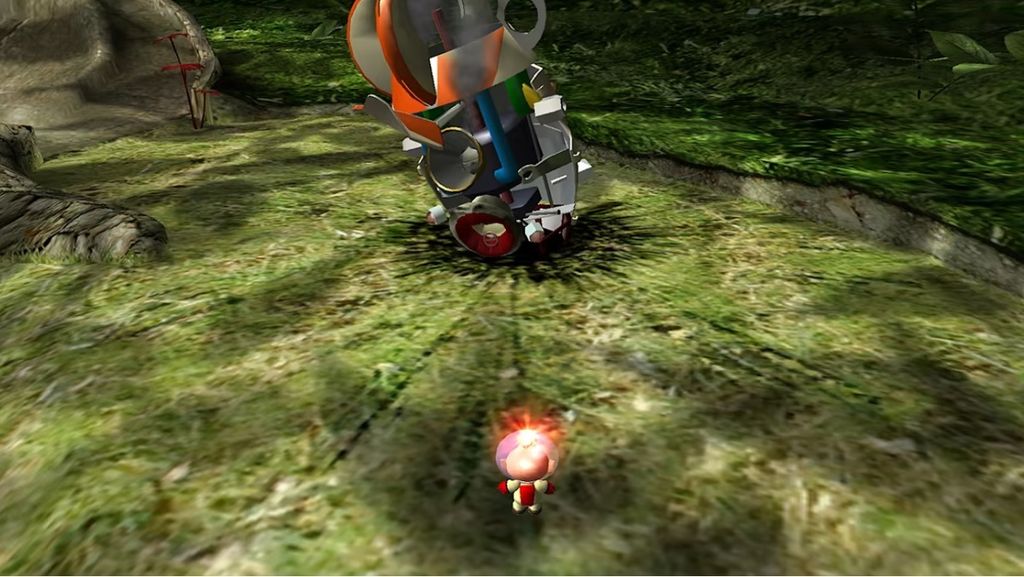 A small, pink, cartoonish character with red accents is running towards a large, metallic, broken-down machine in a grassy, outdoor environment.