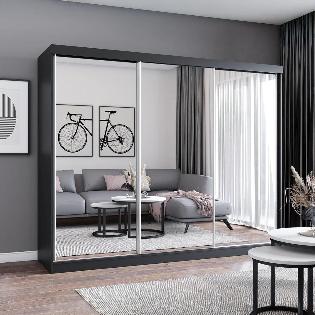 A living room scene with a large mirrored wardrobe reflecting a sofa and coffee table.