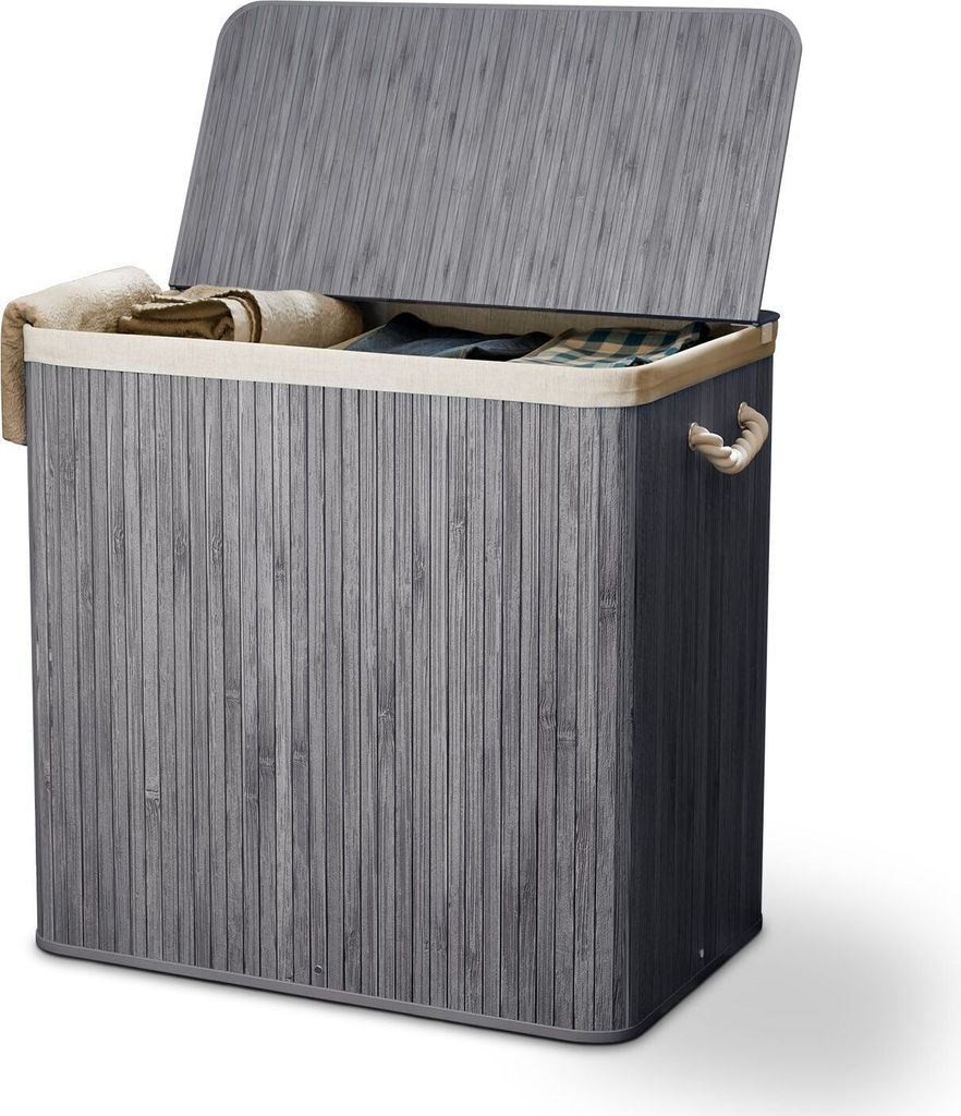 A grey bamboo laundry basket with a lid and beige lining, containing folded laundry.