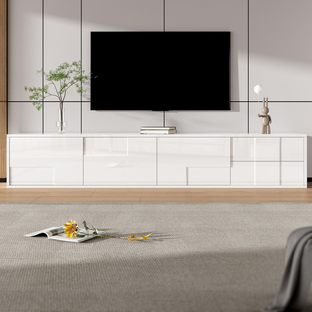 A modern white TV stand with a large black TV mounted above it, set in a clean, minimalist room.