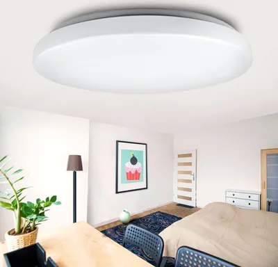 A modern bedroom with a ceiling light, bed, dresser, and artwork.